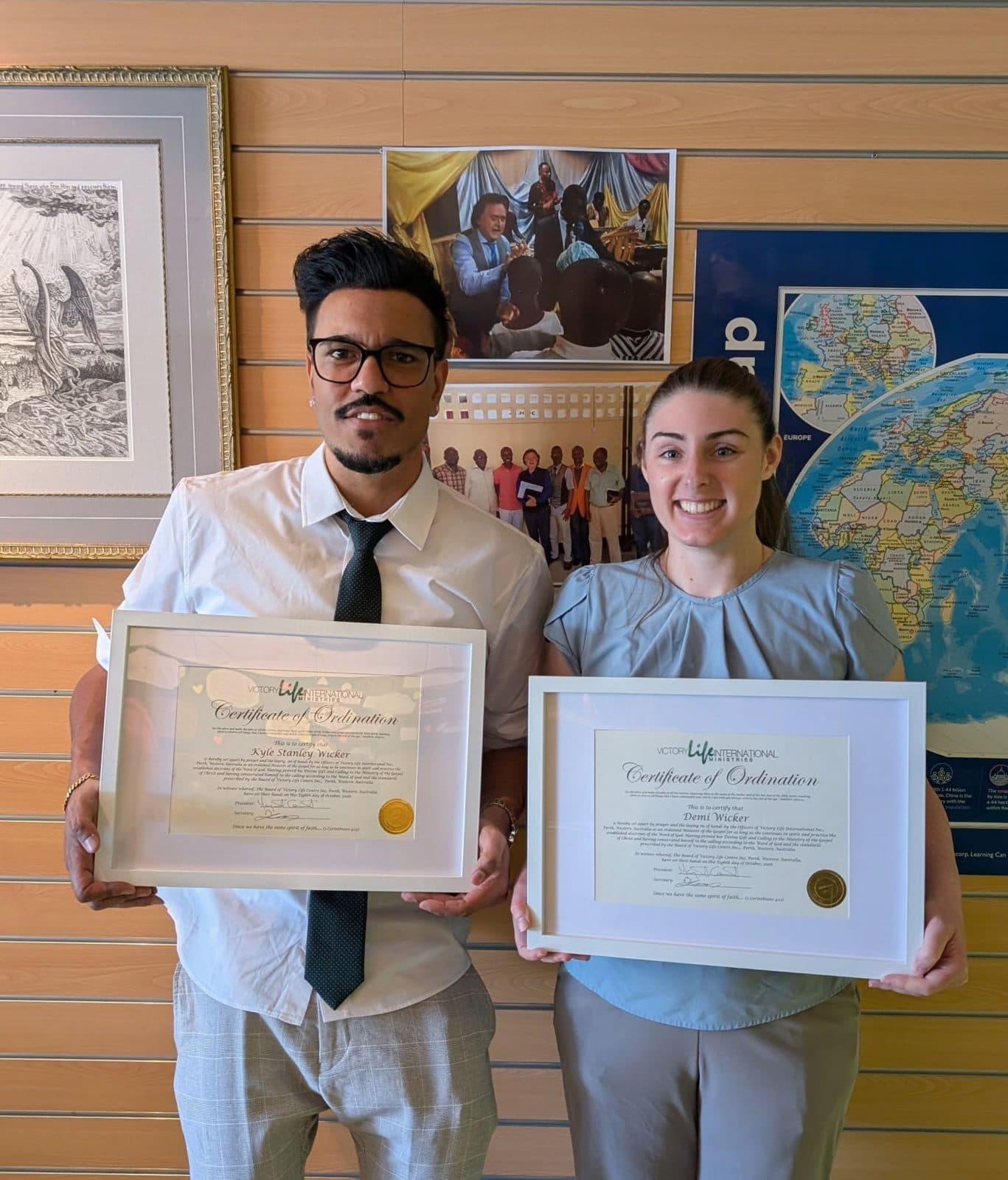 Pastor Kyle and Pastor Demi Wicker holding their certificates of ordination