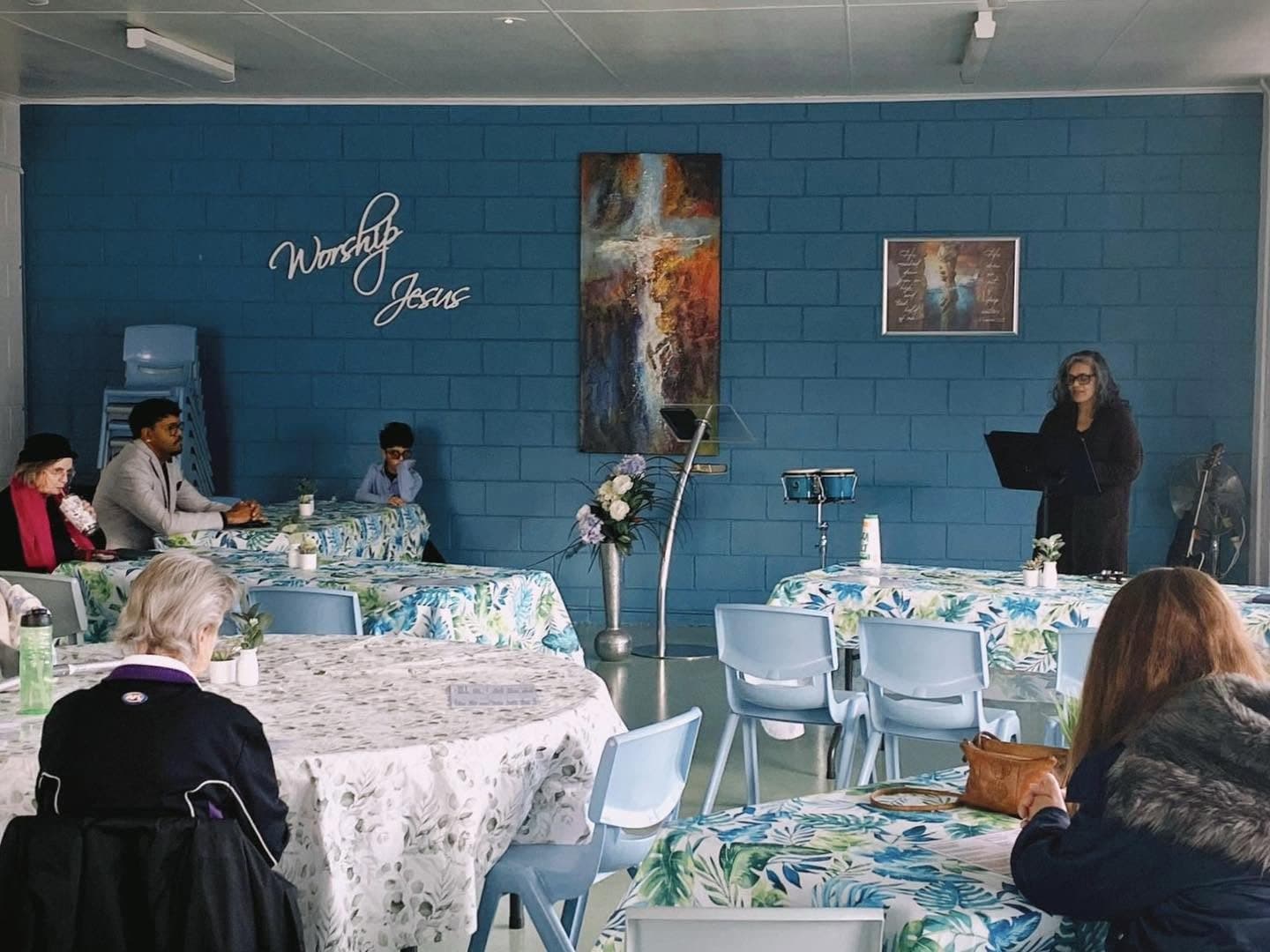 Tables set for lunch at Table of Hope, with people sitting and talking